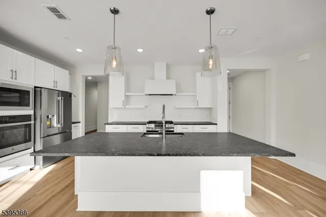 a kitchen with kitchen island granite countertop a counter space cabinets and stainless steel appliances