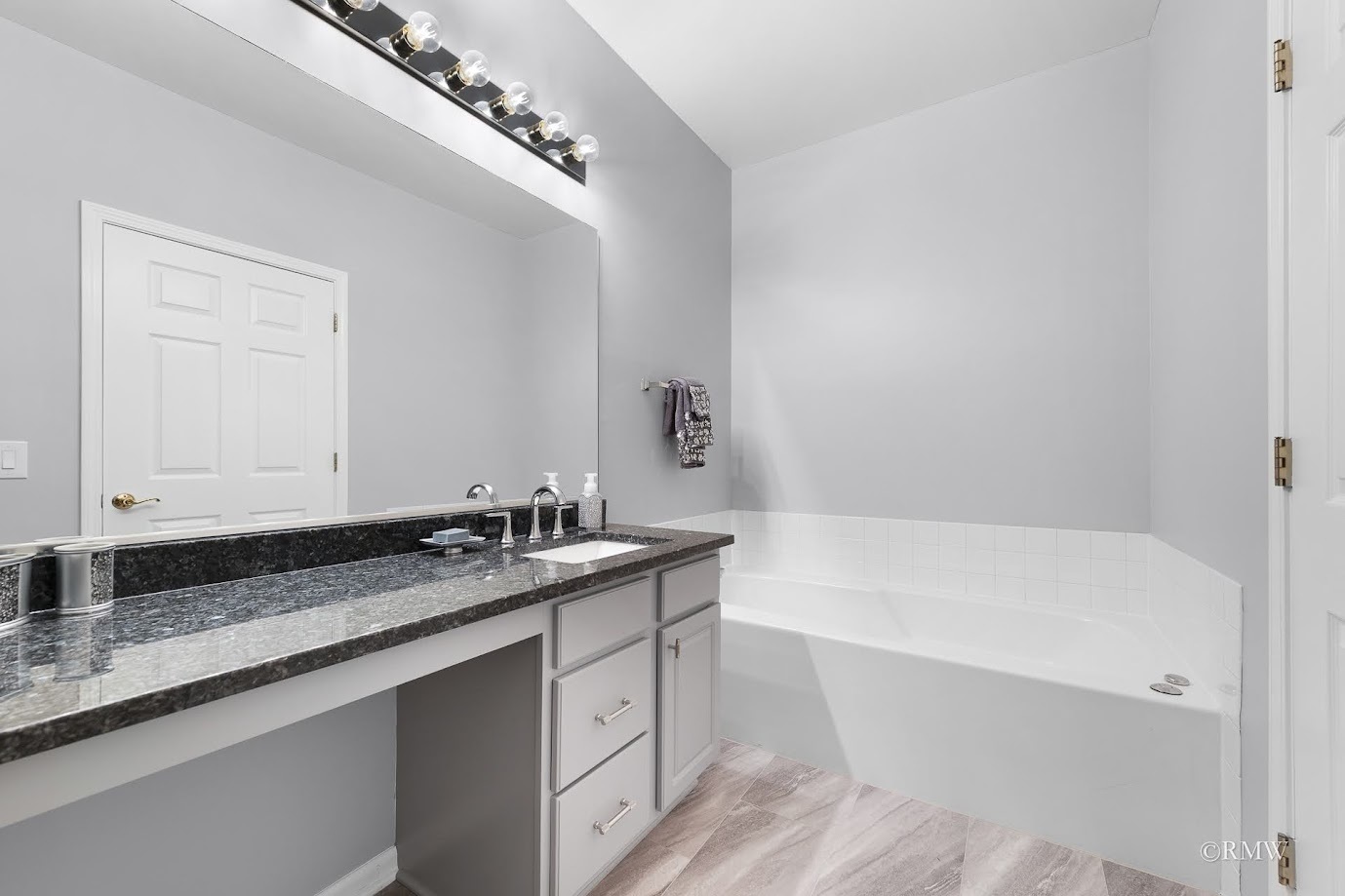101 Bay Drive Itasca, IL 60143 - Photo 22 of 29 a bathroom with a granite countertop bathtub a sink and a mirror