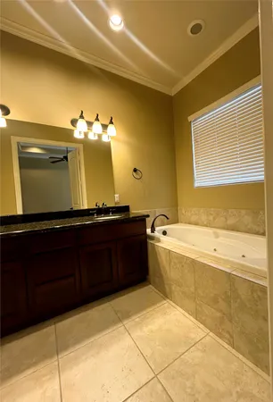 a spacious bathroom with a tub sink and mirror