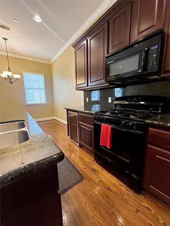 a kitchen with stainless steel appliances granite countertop a stove a sink and a microwave