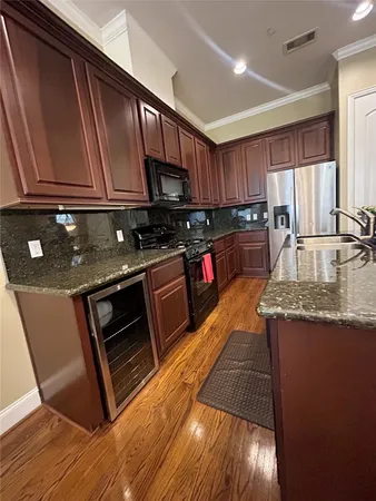 a kitchen with stainless steel appliances granite countertop a stove a sink and a microwave
