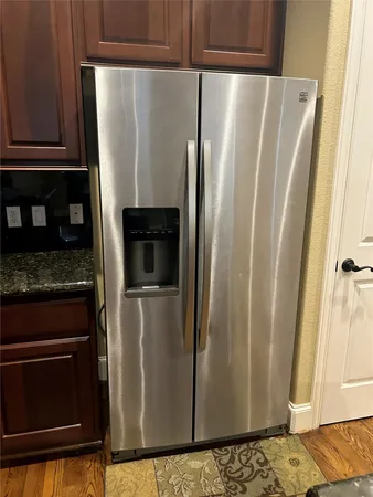 a metallic refrigerator freezer sitting in a kitchen