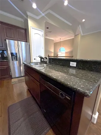a kitchen with stainless steel appliances granite countertop a sink a stove and a refrigerator