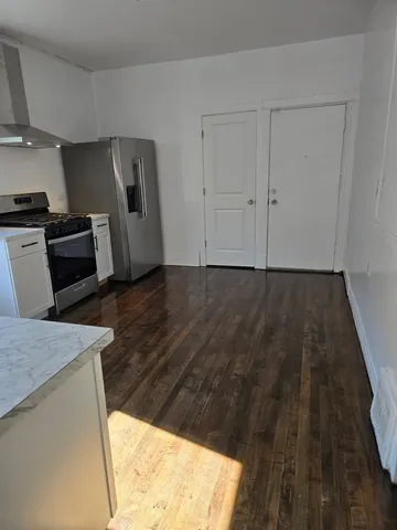 a view of a refrigerator in kitchen and wooden floor