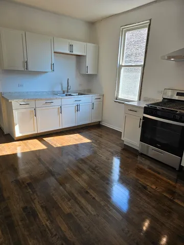 a kitchen with wooden floors and a sink