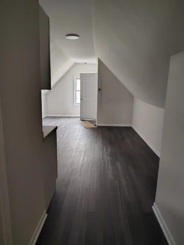 a view of a hallway with wooden floor and stairs