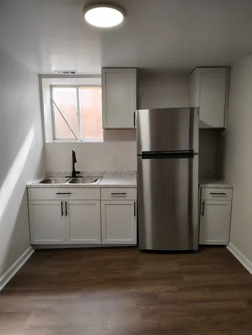 a kitchen with a refrigerator sink stove and cabinets