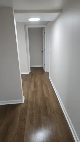 an empty room with wooden floor and door