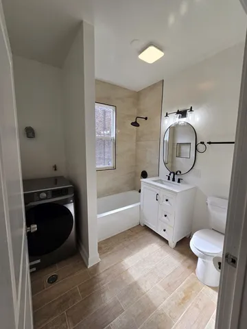 a bathroom with a granite countertop toilet sink and mirror