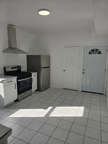 a kitchen with granite countertop a stove a sink and a refrigerator