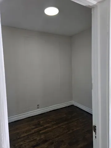 a view of a small space with wooden floor and a window