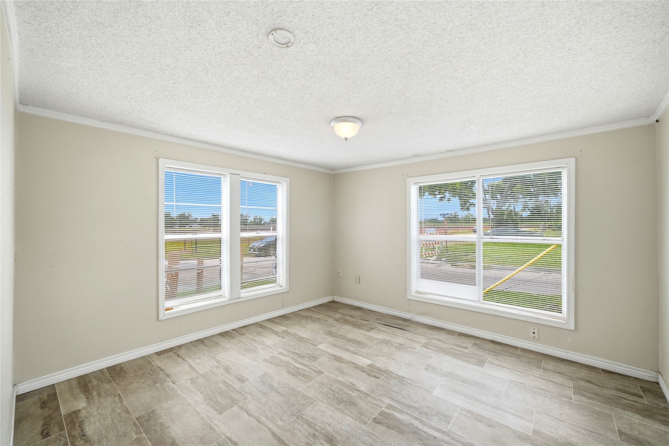 101 Outlar Street Wharton, TX 77488 - Photo 16 of 40 an empty room with wooden floor and windows
