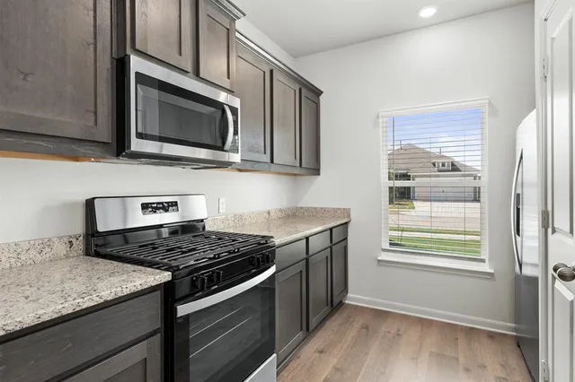 a kitchen with stainless steel appliances granite countertop a stove microwave and sink
