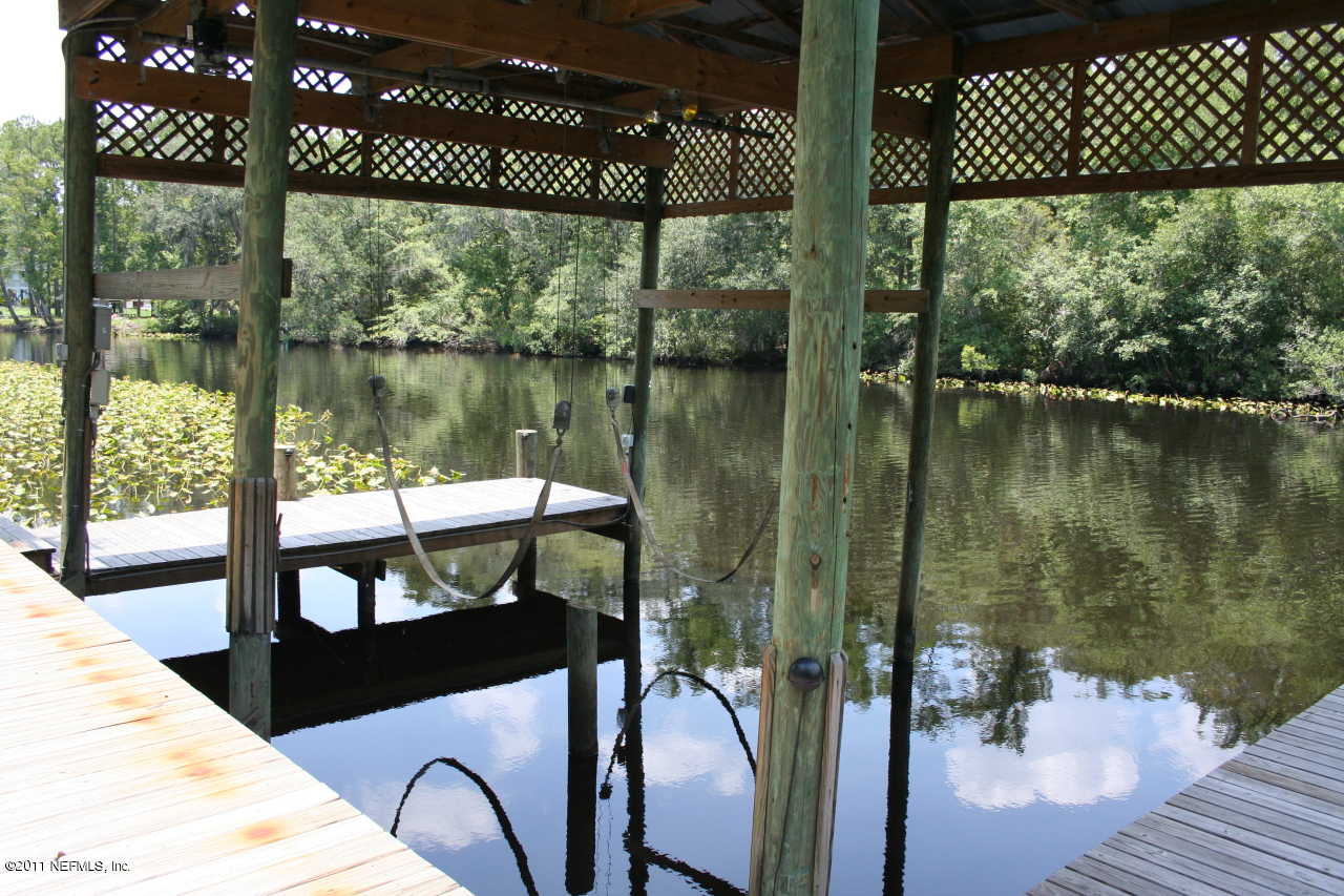 1980 Cornell Road Middleburg, FL 32068 - Photo 6 of 12 a wooden bench sitting next to a lake
