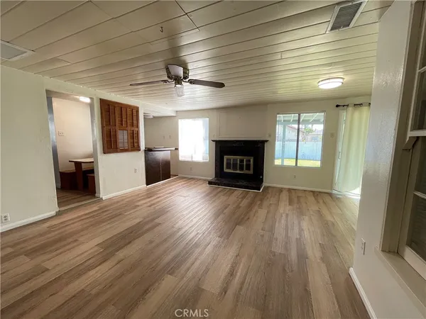 a view of empty room with wooden floor and fireplace