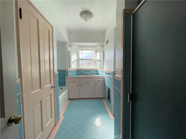 a bathroom with a tub sink and mirror