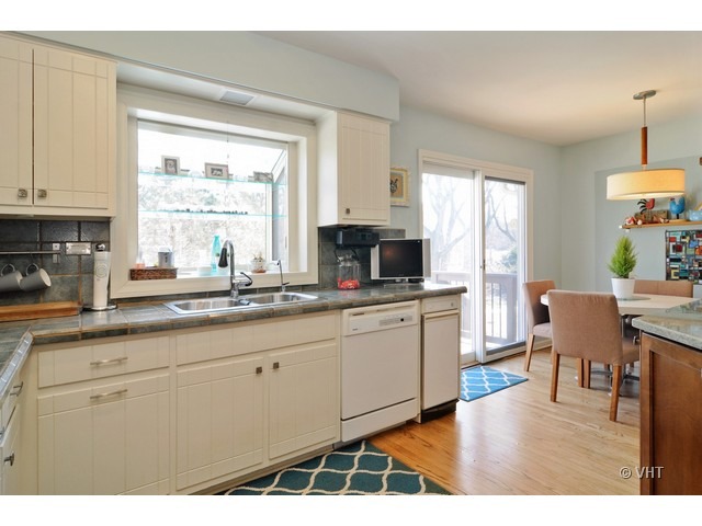 170 Cold Spring Road Barrington, IL 60010 - Photo 4 of 10 a open kitchen with granite countertop a stove a sink a dining table and chairs