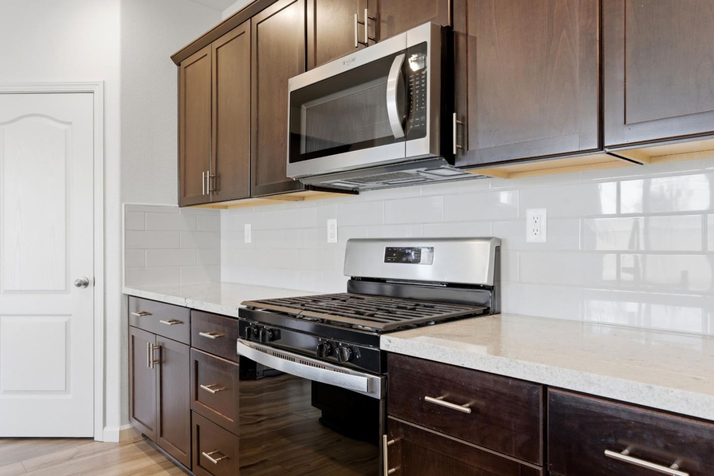 331 Lolly Way Los Banos, CA 93635 - Photo 21 of 31 a kitchen with stainless steel appliances granite countertop a stove and a microwave