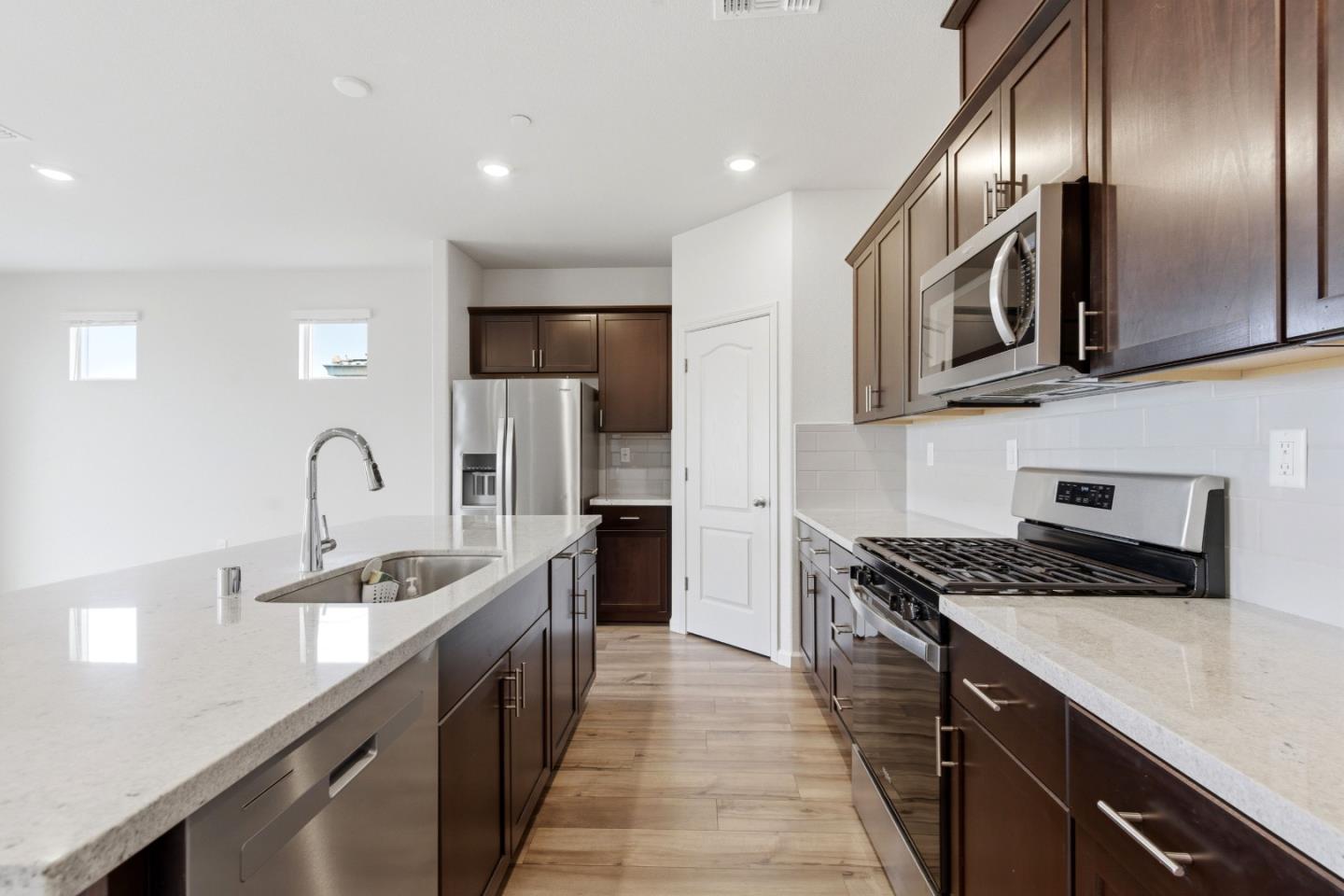 331 Lolly Way Los Banos, CA 93635 - Photo 22 of 31 a kitchen with stainless steel appliances granite countertop a sink a stove and cabinets