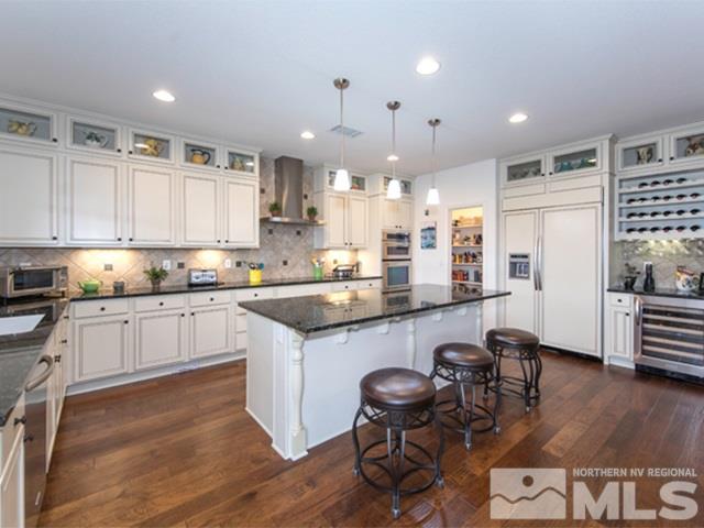 2035 Back Nine Trail Reno, NV 89523 - Photo 8 of 25 a kitchen with stainless steel appliances kitchen island granite countertop a table chairs refrigerator and microwave