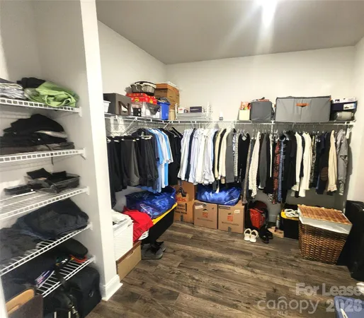 a view of walk in closet with clothes and shoes
