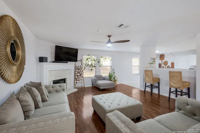 a living room with furniture a fireplace and a flat screen tv