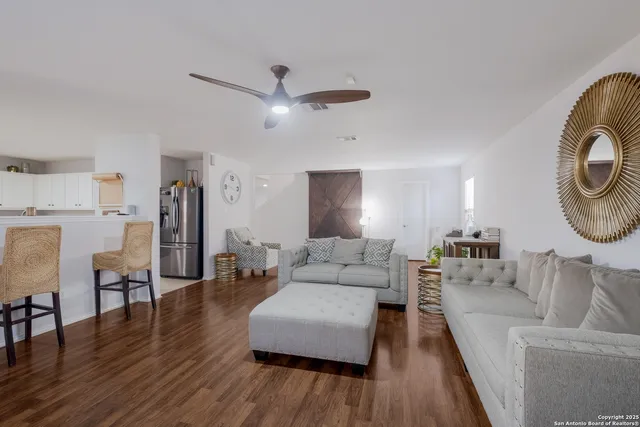 a living room with furniture and a wooden floor