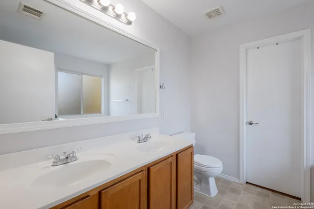 a bathroom with a sink a toilet and a mirror