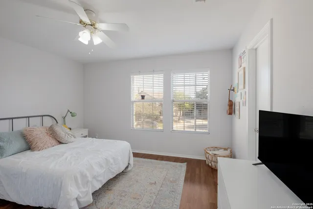 a spacious bedroom with a bed and a flat screen tv