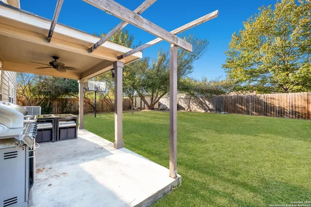 a view of a porch with couches and table and chairs under an umbrella