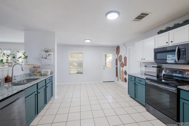 a kitchen with stainless steel appliances granite countertop a sink and a stove