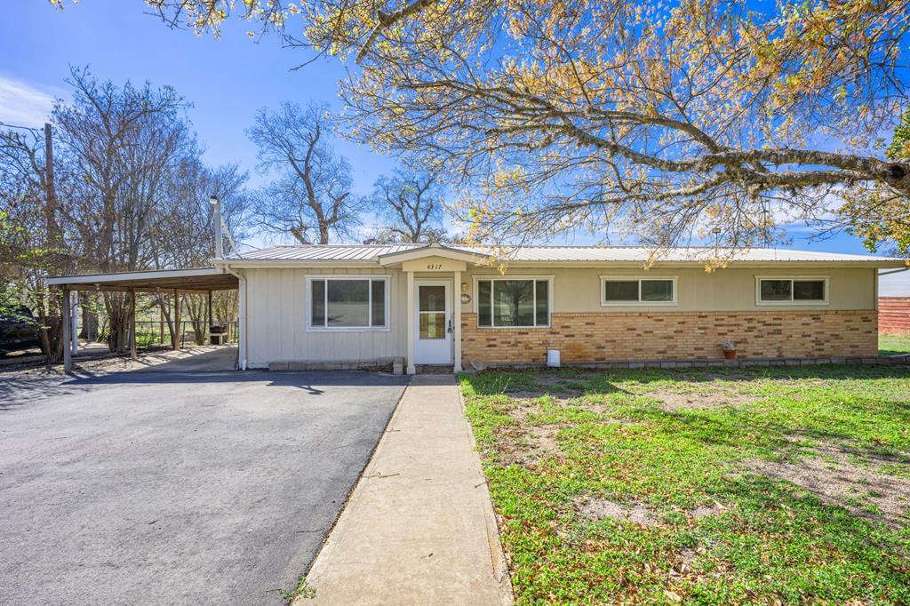 4317 Highway 173 Bandera, TX 78003 - Photo 2 of 35 a front view of a house with a garden and yard