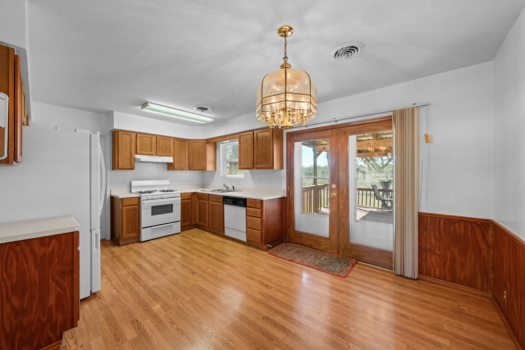 4317 Highway 173 Bandera, TX 78003 - Photo 7 of 35 a large kitchen with stainless steel appliances granite countertop a stove oven and a refrigerator with wooden floor