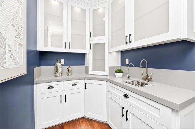 a kitchen with white cabinets and a sink