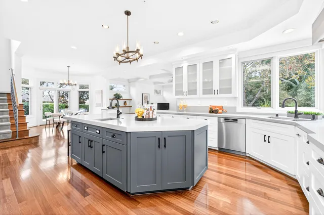 a kitchen with stainless steel appliances granite countertop a sink a stove and a wooden floors