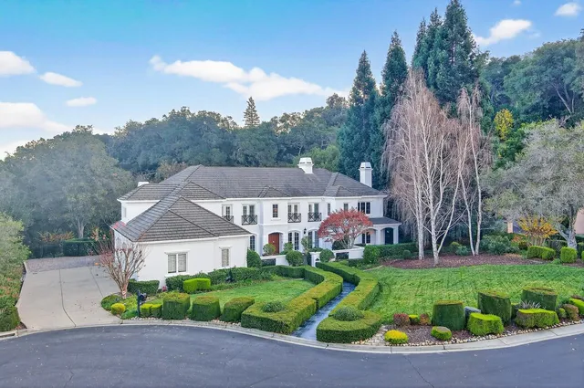 a aerial view of a house with a big yard plants and large trees