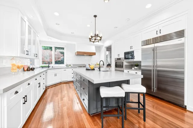 a large kitchen with granite countertop lots of counter top space and stainless steel appliances