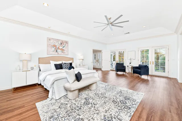 a spacious bedroom with a bed and wooden floor