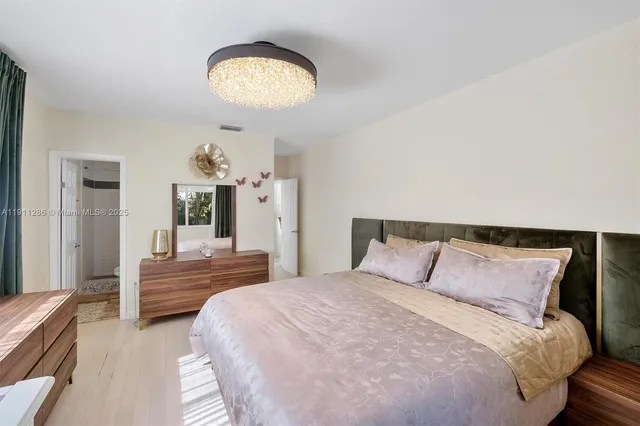 a bedroom with a bed and a chandelier