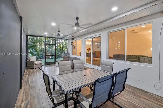 a view of a dining room with furniture large windows and wooden floor