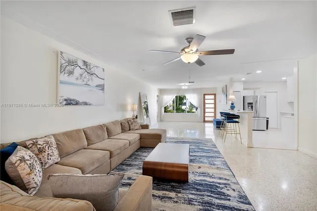 a living room with furniture ceiling fan and a rug