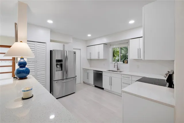 a kitchen with a refrigerator and white cabinets