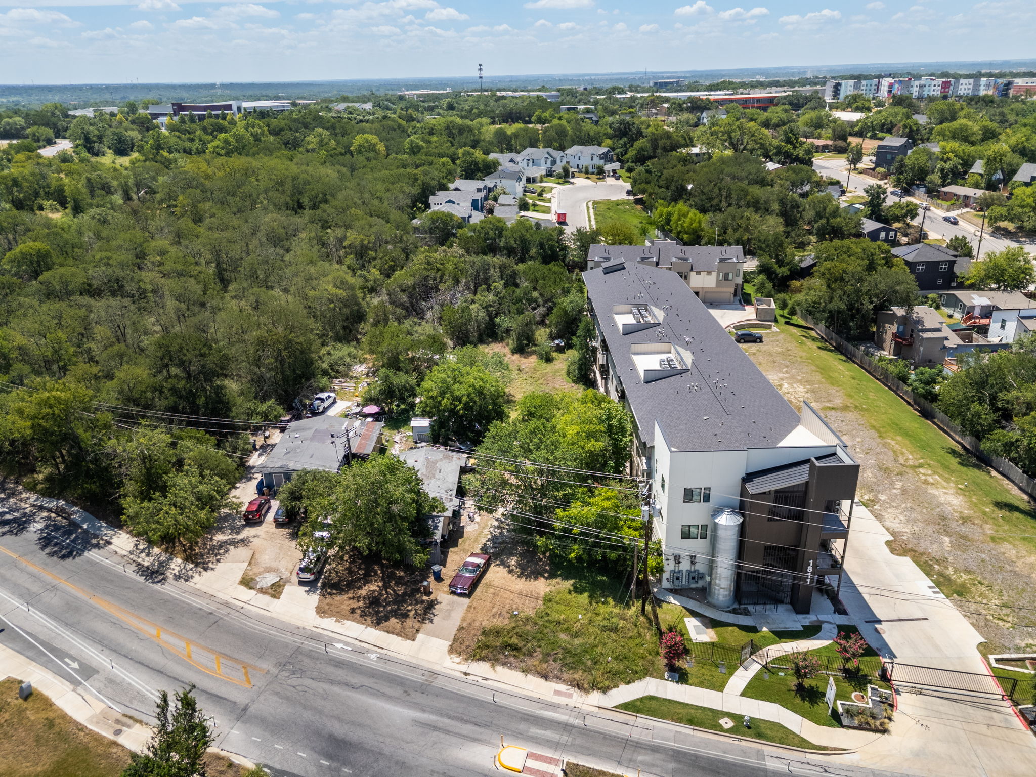 1813 Webberville Road Austin, TX 78721 - Photo 17 of 20 An aerial perspective reveals a modern multi-story complex nestled amidst abundant greenery, offering a serene residential setting.