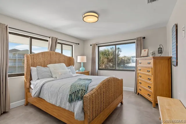 a bedroom with a bed and a dresser next to a window