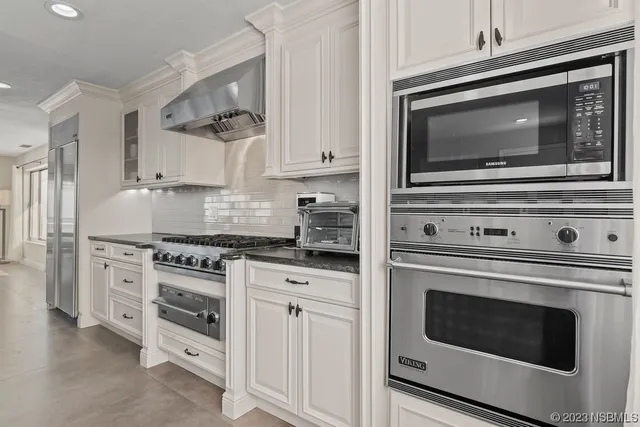 a kitchen with granite countertop white cabinets and appliances