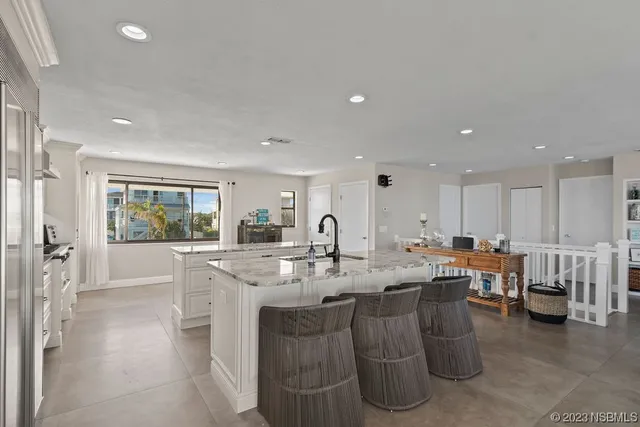 a large dining hall with stainless steel appliances granite countertop a stove and a dining table view with living room