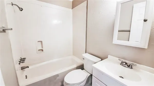 a white toilet sitting next to a bath tub