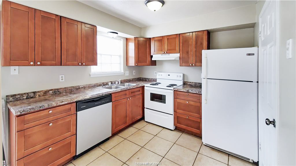 1908 Barak Lane, Unit 15 Bryan, TX 77802 - Photo 4 of 11 a kitchen with granite countertop cabinets and white appliances