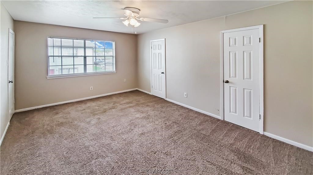 1908 Barak Lane, Unit 15 Bryan, TX 77802 - Photo 7 of 9 an empty room with windows and ceiling fan