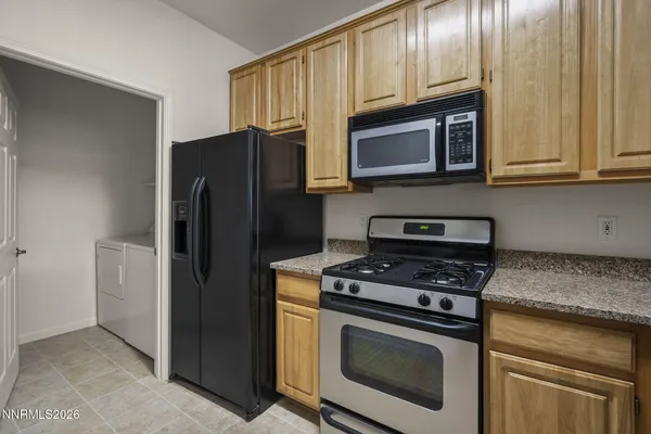 a kitchen with stainless steel appliances granite countertop a refrigerator stove and microwave